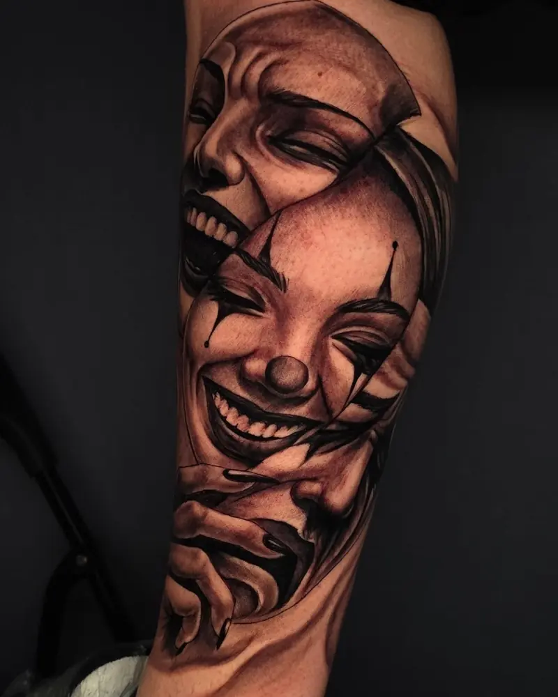Tatuaggio delle maschere smile now cry later sul braccio, black and grey